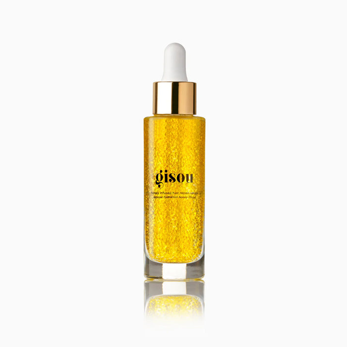 Frasco de vidrio del suero capilar Honey Infused Hair Repair Serum con microcápsulas visibles.
