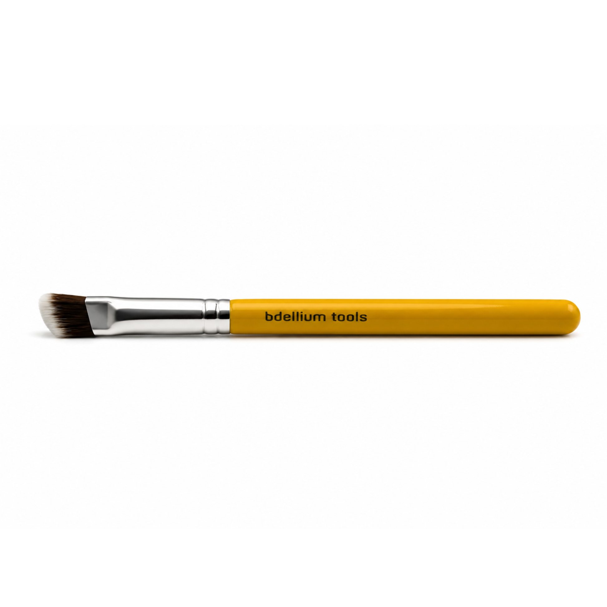 Primer plano de las cerdas sintéticas densas y el perfil plano y cuadrado de la brocha para corrector Bdellium Tools 935.