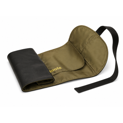 Maquillista profesional abriendo su manta enrollable Studio Roll-Up Pouch llena de brochas en su mesa de trabajo.