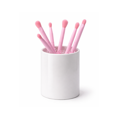 Tubo de acrílico cristalino que permite ver el tono brillante y traslúcido de las brochas para ojos en su interior.