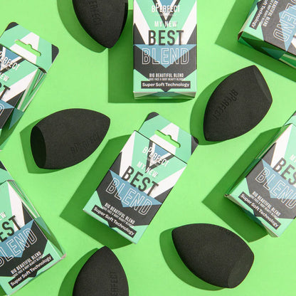 Esponja Big Beautiful Blend rodeada de productos de maquillaje y cuidado facial, mostrando su versatilidad de uso.