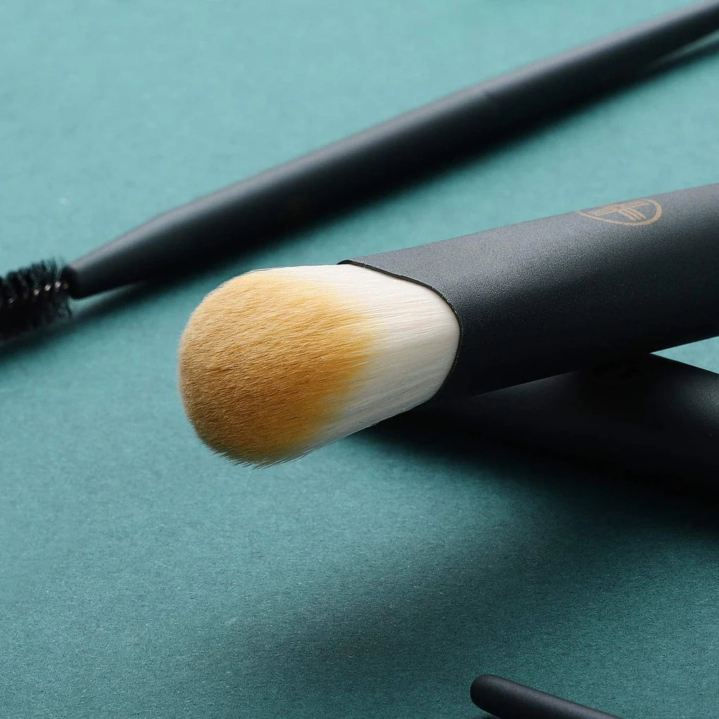 Maquillista utilizando la brocha de rostro y ojos del kit profesional mini Chic Series para un acabado impecable.