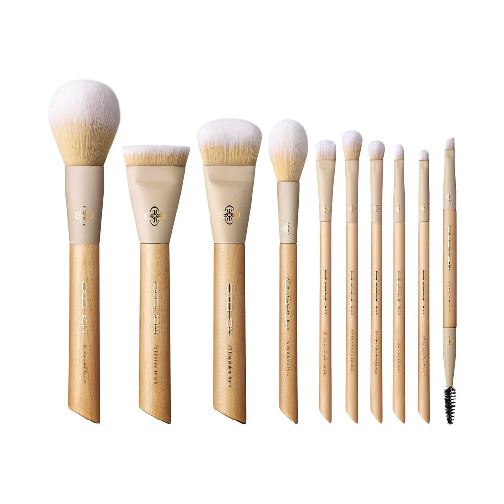 Set profesional de 10 brochas de maquillaje EIGSHOW Origin Series con mangos de madera natural y bolso clutch.